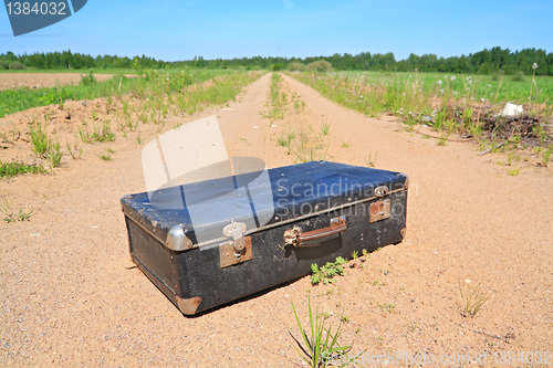Image of old valise on rural road