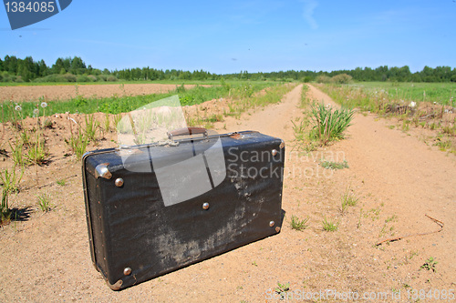 Image of old valise on rural road 