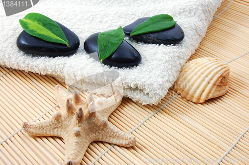 Image of foldet white bath towel and zen stones