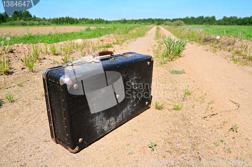 Image of old valise on rural road