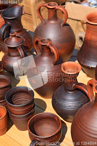 Image of clay pitchers on yellow background