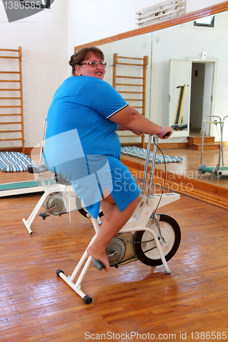 Image of overweight woman exercising on bike