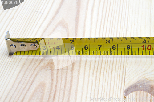 Image of Tape measure on wood background 