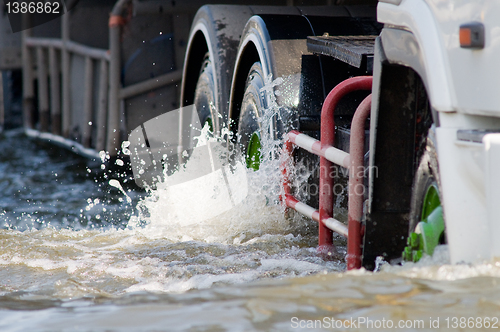 Image of Detail of truck driving on a flooded road