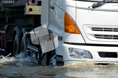 Image of Detail of truck driving on a flooded road