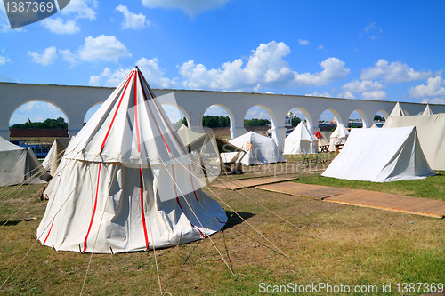 Image of white tents near ancient wall