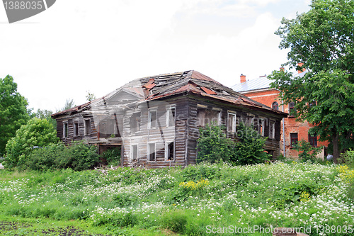 Image of old wooden house on green field