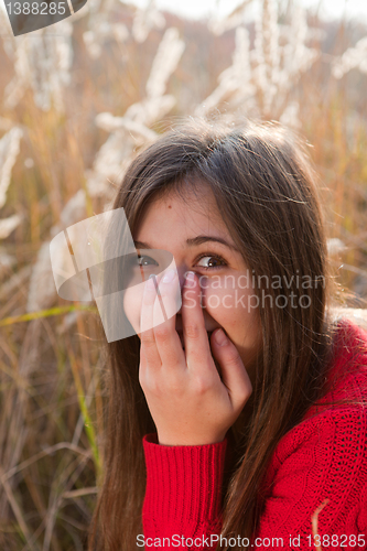 Image of Portrait of girl covering her mouth with hand