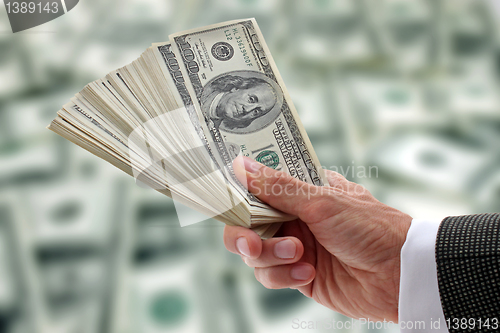 Image of businessman holding dollars