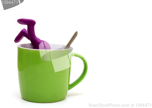 Image of Purple puppet of plasticine sinking in cup