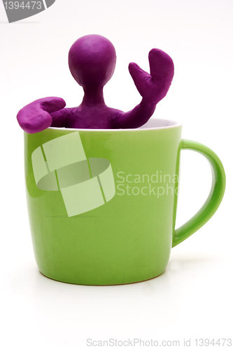 Image of Purple puppet of plasticine signing from cup