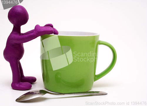 Image of Purple puppet of plasticine rest on cup