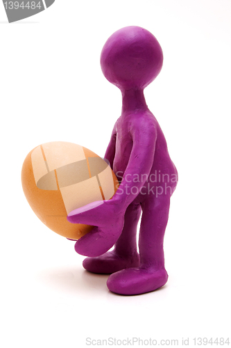Image of Purple puppet of plasticine holding one egg
