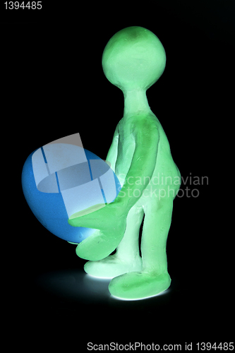 Image of Shaded puppet of plasticine holding one egg