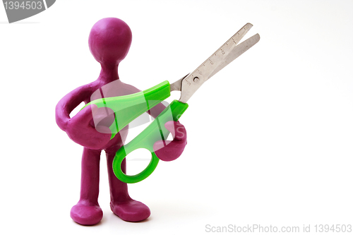 Image of Purple puppet of plasticine holding green scissors