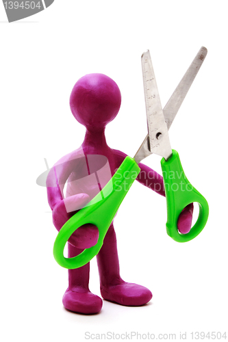 Image of Purple puppet of plasticine holding green scissors