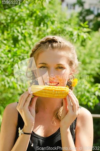 Image of woman eating corn-cob