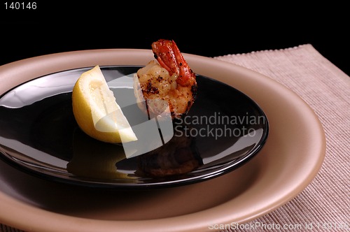 Image of Shrimp and lemon on black plate