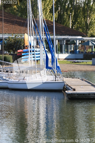 Image of Blue canoes and white sailboats