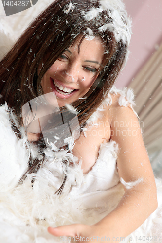Image of Happy woman among feathers