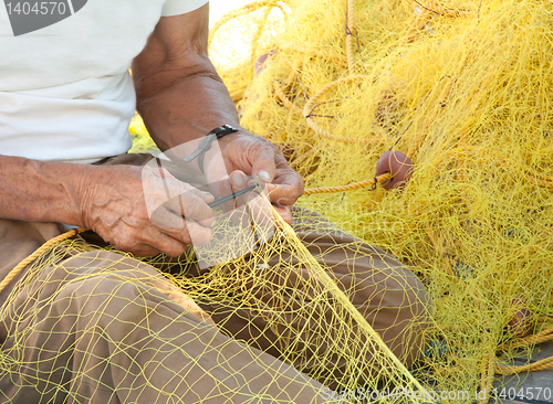 Image of Fisherman Mending His Fishing Net in Greece