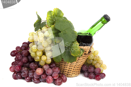 Image of white and red grape with leaves and bottle of wine