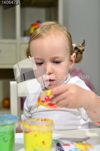 Image of little girl draws with colored inks 