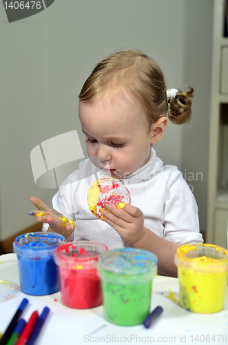 Image of little girl draws with colored inks 