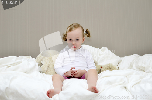 Image of little girl sitting on a bed