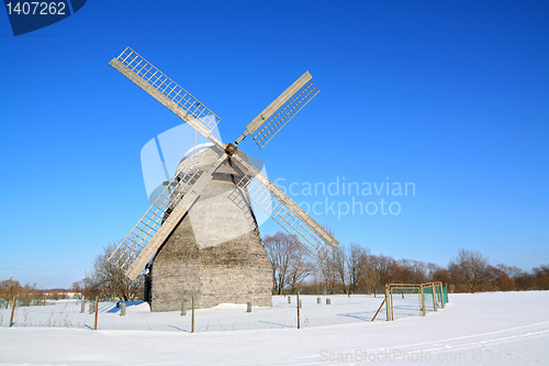 Image of aging wind mill on winter field 