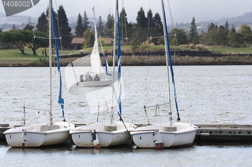 Image of three sailing boats with mountain in background