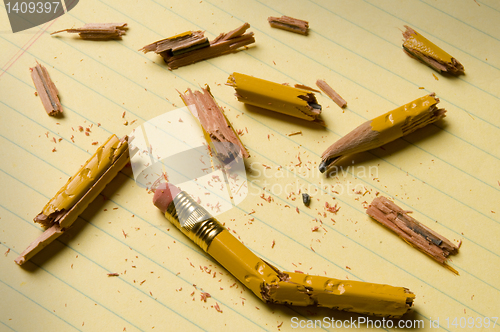Image of Broken pencil fragments on yellow paper