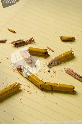 Image of Broken pencil fragments on yellow paper