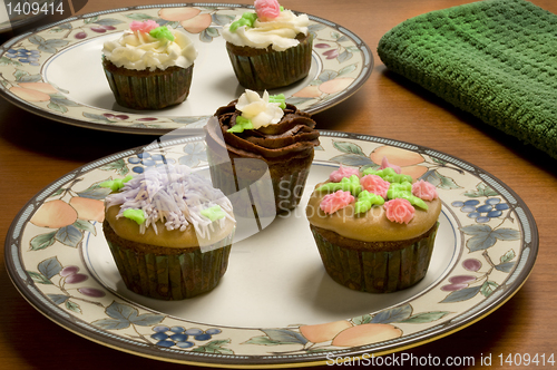 Image of Ornately decorated cupcakes on plates