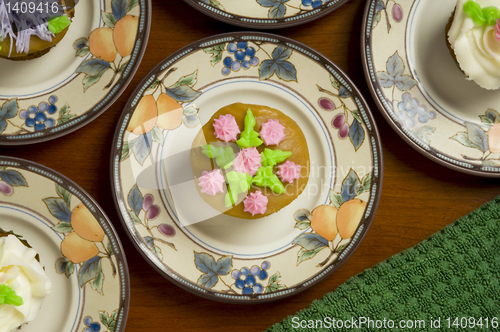 Image of Ornately decorated cupcakes on dishes