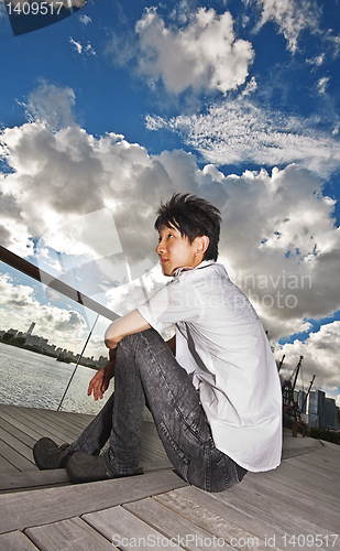 Image of asian man sitting in park