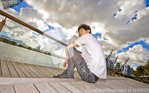 Image of asian man sitting in park