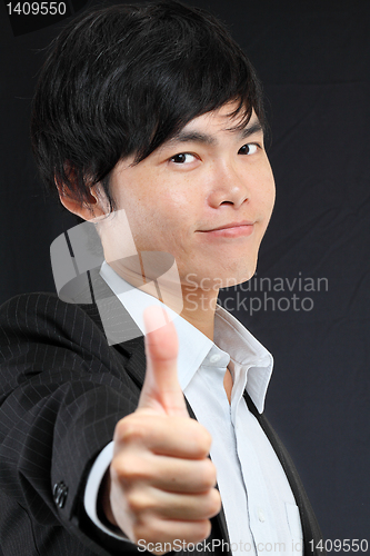 Image of portrait of young man in suit and thumbs up