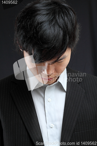 Image of young asian man looking down