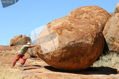 Image of man pushing devil marbles