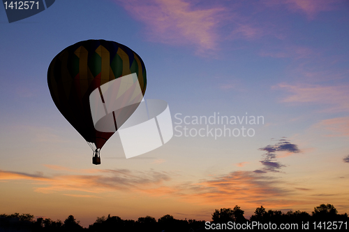 Image of Hot-air balloon floating against a reddish dawn sky