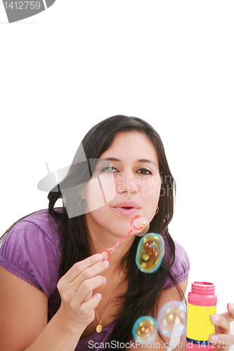 Image of Young woman portrait making soap bubbles. 