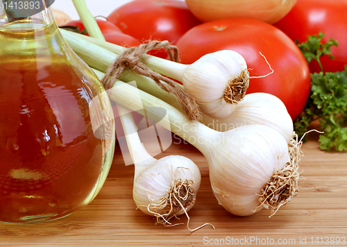 Image of Fresh Garlic with stems and tied with twine, tomatoes, parsley, 