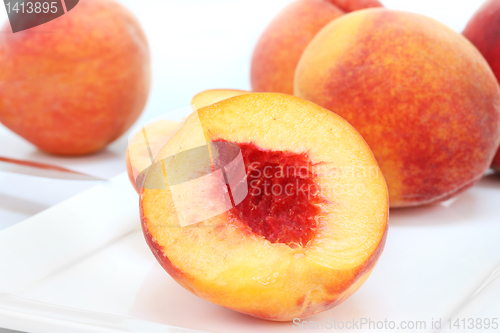 Image of Open peach macro on white plate with selective focus on center.