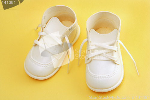 Image of baby shoes over yellow