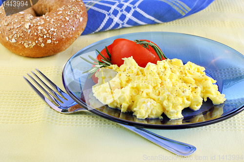 Image of Scrambled eggs with tomatoes and fresh rosemary.