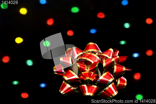 Image of Red and Gold Bow in front of bokeh lights.