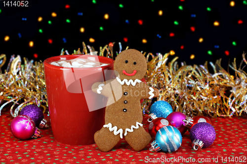 Image of Cocoa and a gingerbread cookie in night setting with Christmas l