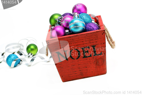 Image of Christmas ornaments in a wooden box with NOEL stenciled on the f