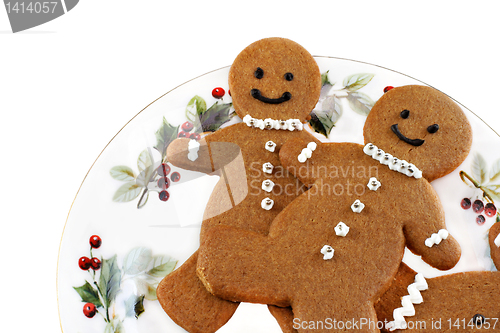 Image of Fresh baked gingerbread men cookies on a Christmas Plate.  On wh